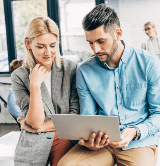 man-and-woman-dicussing-on-laptop